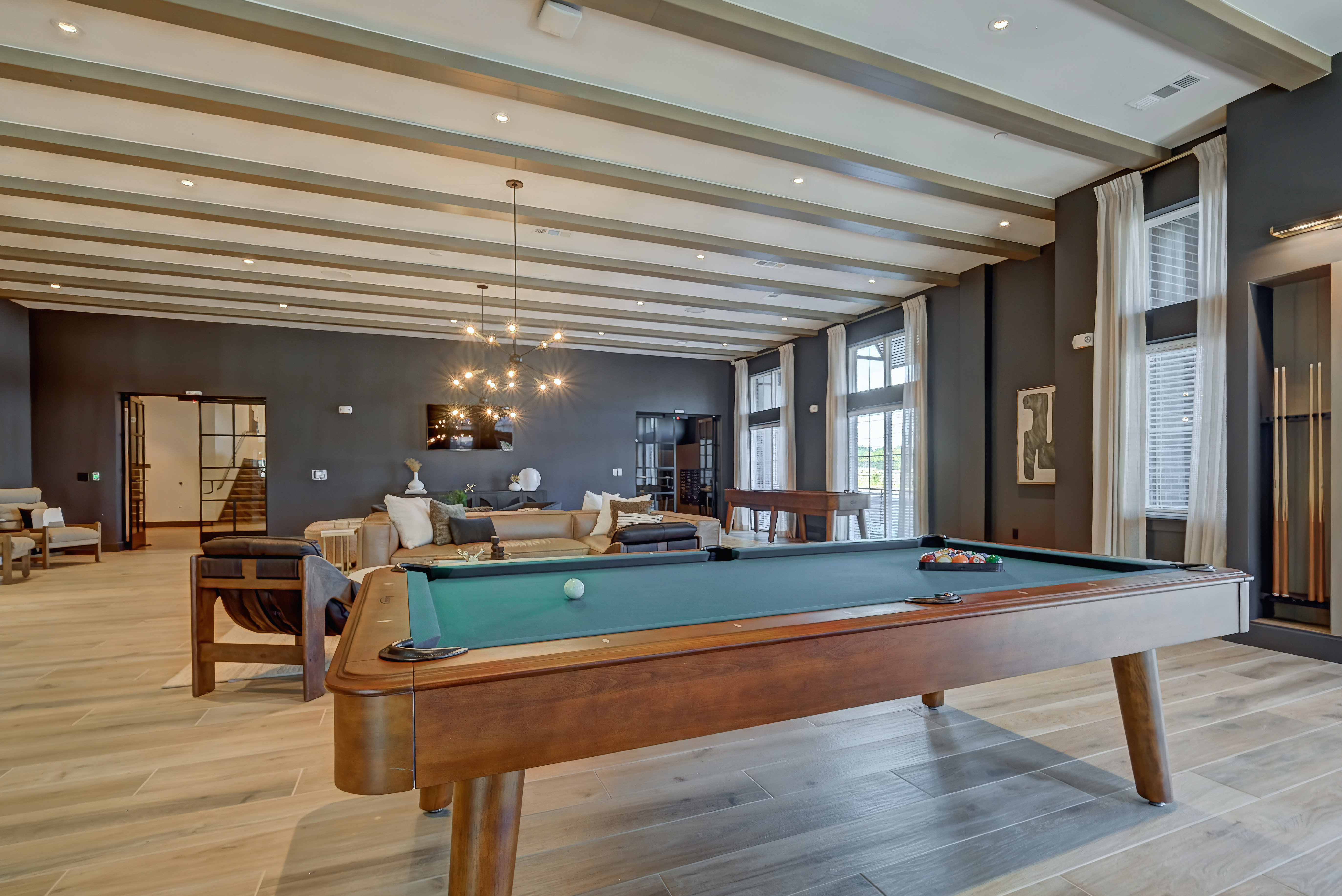 Luxury apartment clubhouse with pool table, modern lounge seating, and upscale interior design