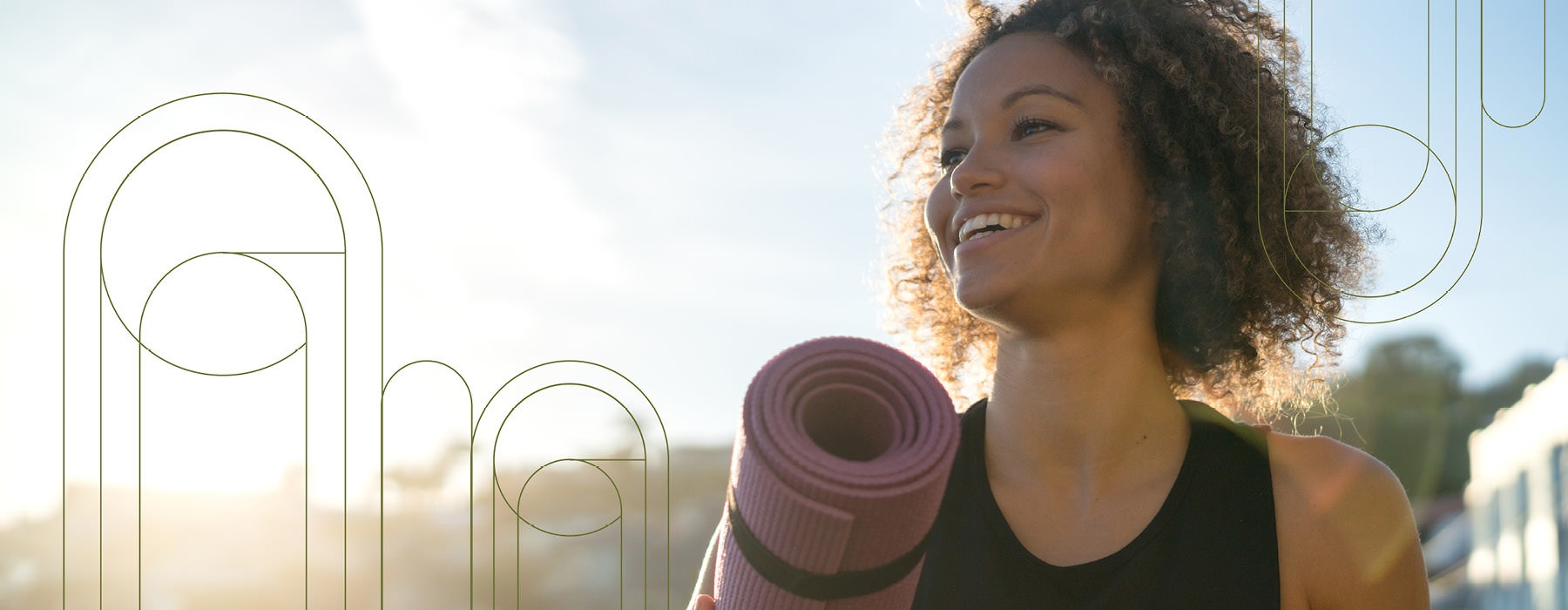 woman outside holding a yoga mat