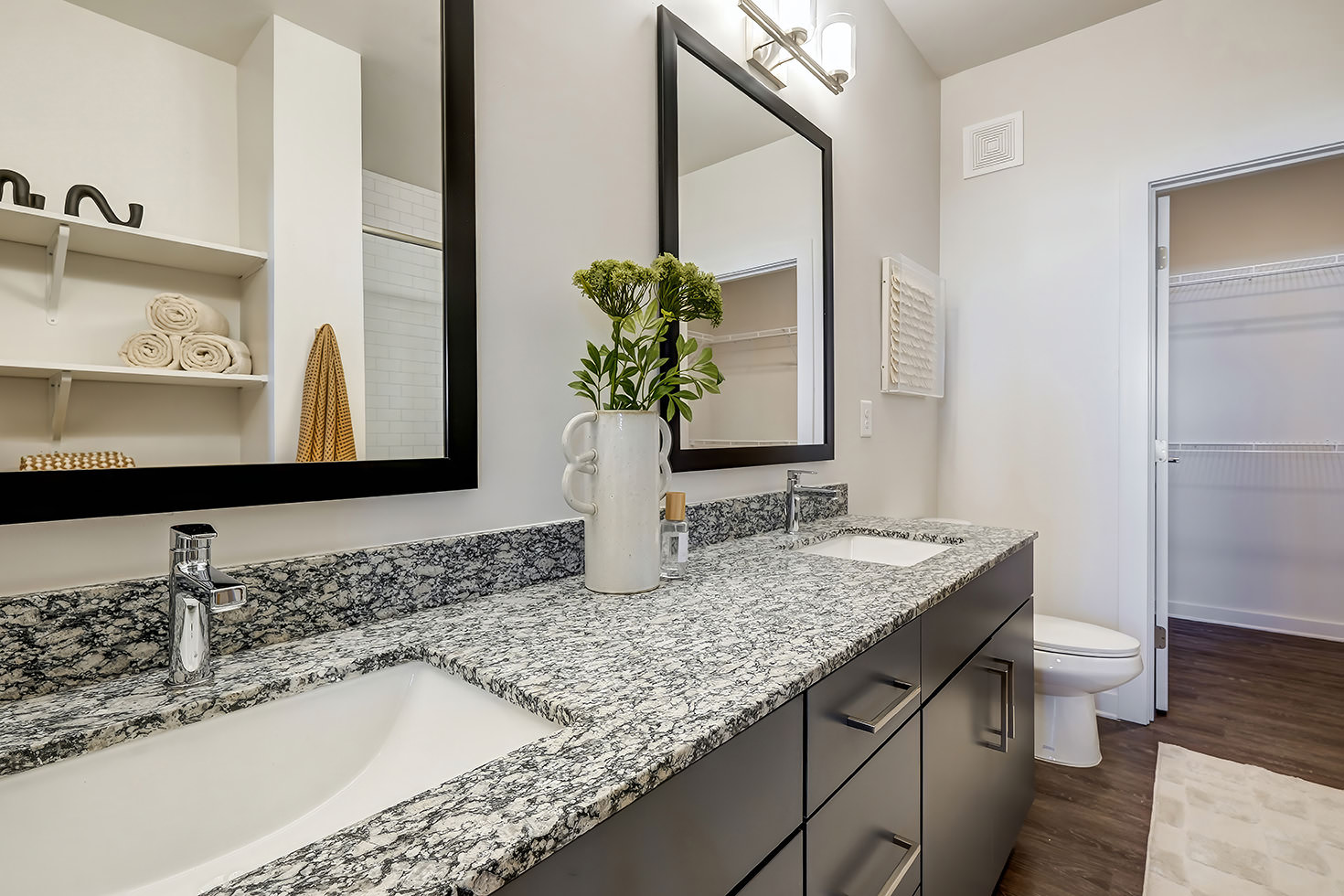 dual sinks in bathroom with walk-in closet